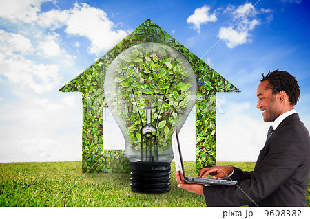 Composite image of businessman working on laptop 9608382