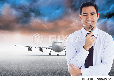 Composite image of smiling businessman holding glasses 9608972