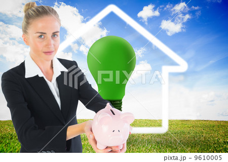 Composite image of businesswoman holding piggy bank 9610005