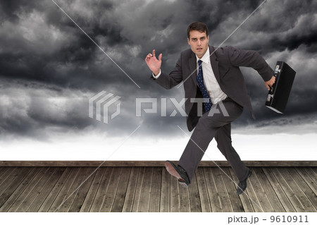 Composite image of stern businessman in a hury Composite image of stern businessman in a hury 9610911