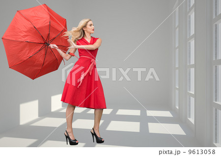 Composite image of beautiful woman posing with a broken umbrella Composite image of beautiful woman posing with a broken umbrella 9613058