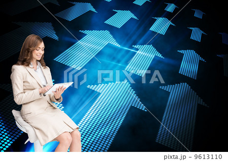 Composite image of happy businesswoman using tablet 9613110