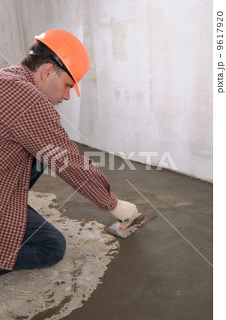 Construction worker spreading wet concrete Construction worker spreading wet concrete 9617920