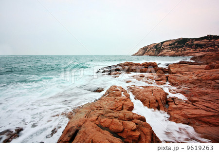 rocky sea coast and blurred water in shek o,hong kong 9619263