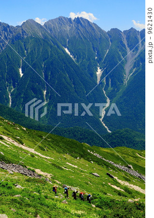 北アルプス・杓子平上部から穂高連峰と下る登山者 9621430