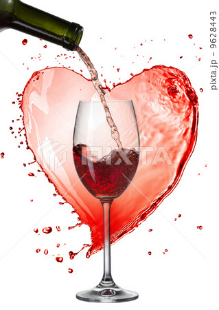 Red wine pouring into glass with splash against heart isolated o 9628443