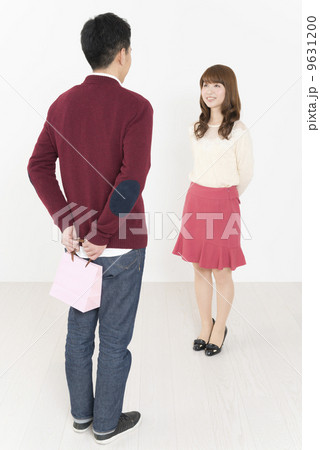 プレゼントの入ったピンク色のオシャレな紙袋を受け渡しする若い男女 プレゼントの入ったピンク色のオシャレな紙袋を受け渡しする若い男女 9631200