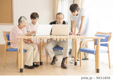 介護士にパソコンを教わるシニア 9631808