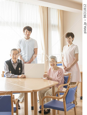 男性と女性の介護士とメッセージボードを持つ高齢の男性と女性 9631812