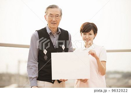 メッセージボードを持つ高齢の男性と女性の介護士 9632022