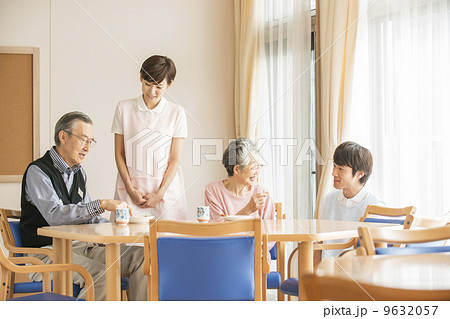 おやつを食べるシニアと見守る看護師 9632057
