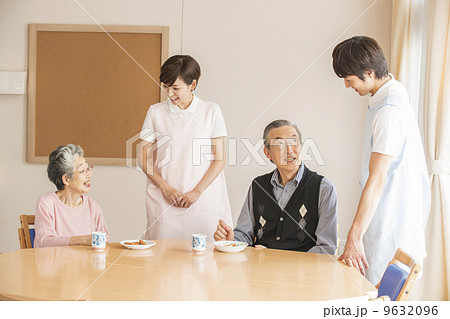 おやつを食べるシニアと見守る看護師 9632096