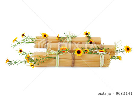 Uncooked Italian spaghetti decorated with yellow flowers isolate Uncooked Italian spaghetti decorated with yellow flowers isolate 9633141