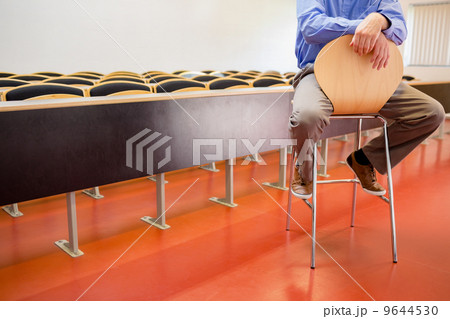 Low section of a teacher on chair in lecture hall 9644530
