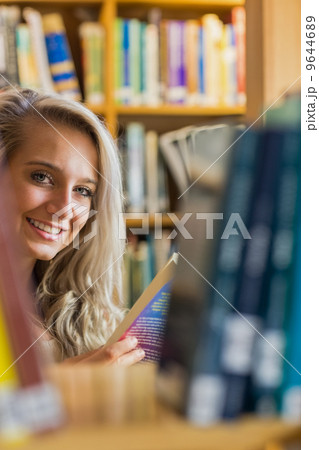 Smiling female amid bookshelves in the library Smiling female amid bookshelves in the library 9644689