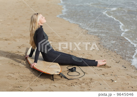 Beautiful blond in wet suit with surfboard at beach Beautiful blond in wet suit with surfboard at beach 9645046