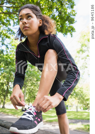 Sporty young woman wearing shoes in park Sporty young woman wearing shoes in park 9645186