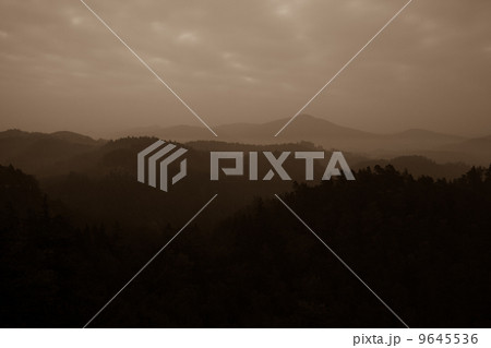 Trees and mountain range against cloudscape 9645536