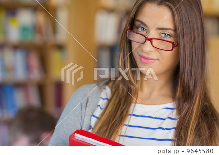 Close up portrait of a smiling female student in library 9645580