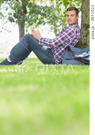 Happy student using his tablet to study outside 9651022