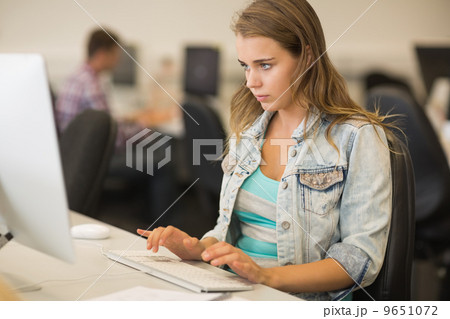 Focused young student working in the computer room Focused young student working in the computer room 9651072