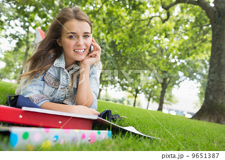 Young pretty student lying on the grass on the phone Young pretty student lying on the grass on the phone 9651387