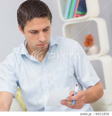 Worried young man paying his bills at home 9651856