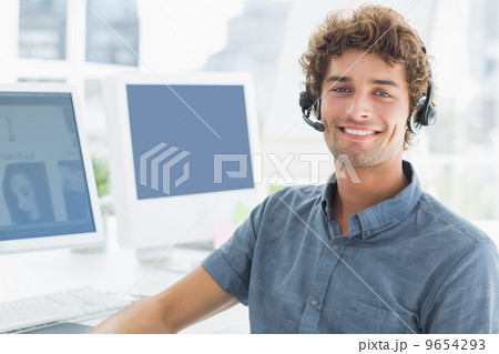 Smiling casual man with headset in the office Smiling casual man with headset in the office 9654293
