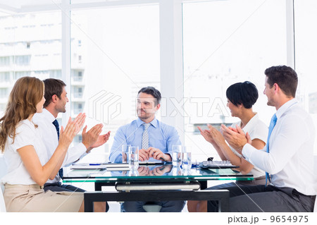 Executives clapping around conference table Executives clapping around conference table 9654975