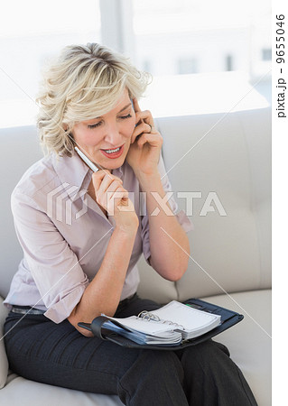 Female secretary with diary while using mobile phone 9655046