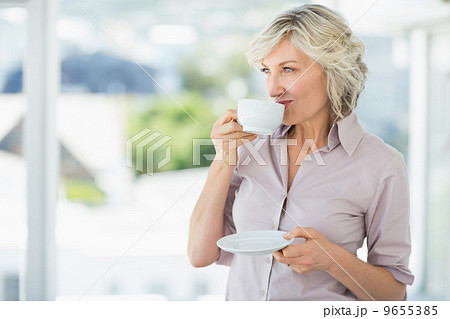 Smiling beautiful businesswoman drinking tea 9655385
