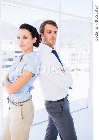 Young business couple standing with arms crossed Young business couple standing with arms crossed 9655397
