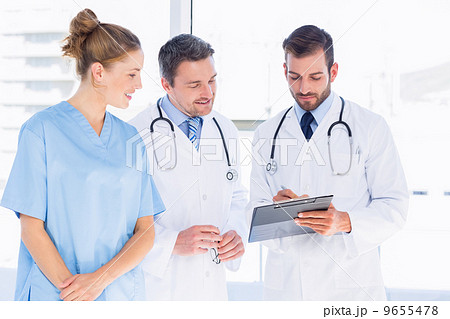 Doctors and female surgeon reading medical reports 9655478