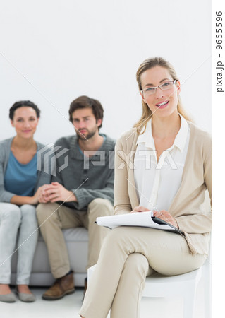 Female financial adviser with young couple in background 9655596