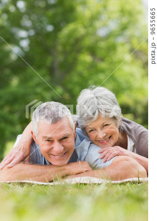 Smiling relaxed senior couple lying in park 9655665