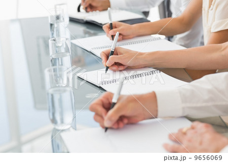 Business people taking down notes at a meeting Business people taking down notes at a meeting 9656069