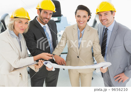 Well dressed architects with hard hats and blueprint 9656210