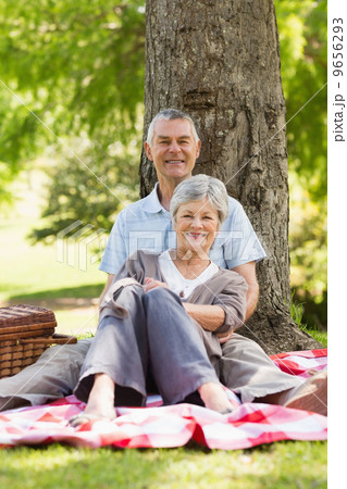 Senior man embracing woman from behind at park 9656293