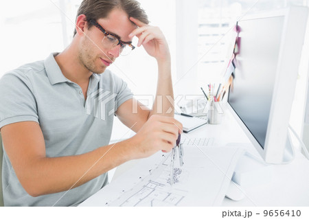 Man using compass on design 9656410