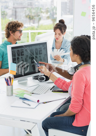 Artists working at desk in creative office 9656456