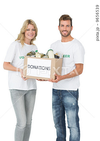 Smiling young couple carrying donation box Smiling young couple carrying donation box 9656539