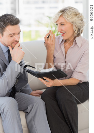 Businessman and his secretary with diary at home Businessman and his secretary with diary at home 9656621