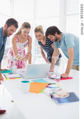 Casual business people using laptop together 9656669