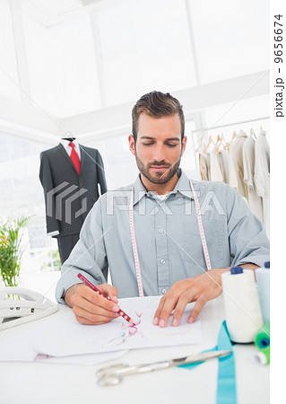 Fashion designer working on his designs in studio 9656674
