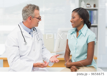Doctor speaking with cheerful young patient 9656675