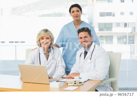 Smiling doctors with laptop at medical office 9656717