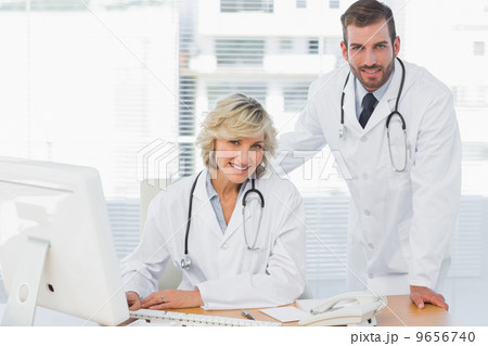 Smiling doctors with computer at medical office 9656740