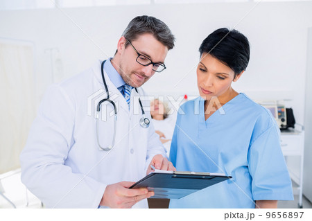 Doctors discussing medical reports 9656897