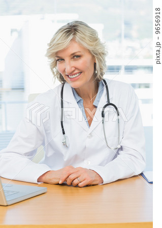 Female doctor sitting at desk in medical office 9656918
