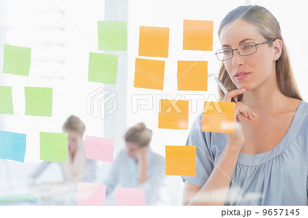 Concentrated artist looking at colorful sticky notes Concentrated artist looking at colorful sticky notes 9657145